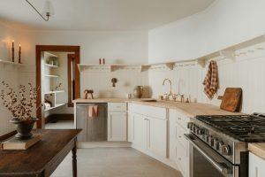 Bright, minimalist kitchen with white cabinets and wooden countertops.