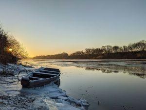 A small boat sitting on top of a frozen river