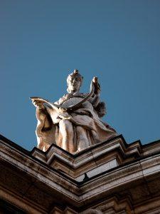 a statue of a woman sitting on top of a building