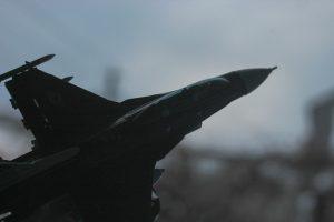 a fighter jet flying through a cloudy sky